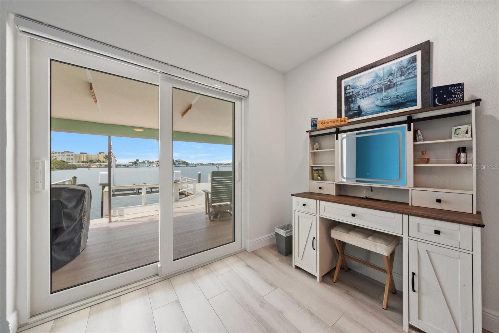 Makeup vanity area featuring stunning waterfront views—watch the dolphins while you get ready. Enjoy seamless access to the patio through the newly installed hurricane-rated sliding glass doors.