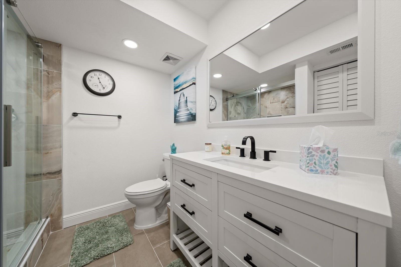 Guest bathroom featuring a custom-built shower and a beautiful vanity.