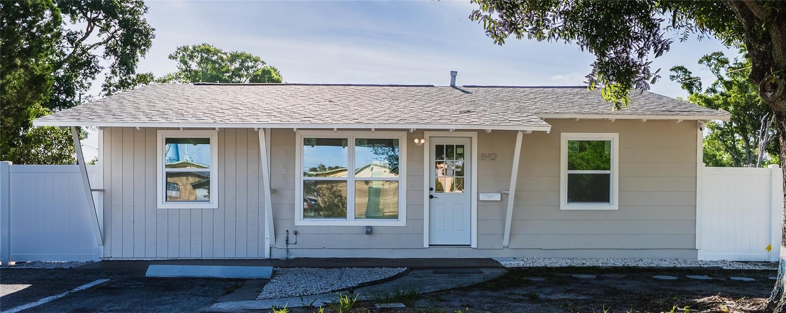 This freshly updated ranch-style home makes an immediate impression with crisp new exterior paint, brand-new windows, and a clean white front door framed by classic decorative brackets. The smooth board-and-batten siding, refreshed roofline, and white vinyl privacy fence deliver polished, move-in-ready curb appeal from the moment you arrive.