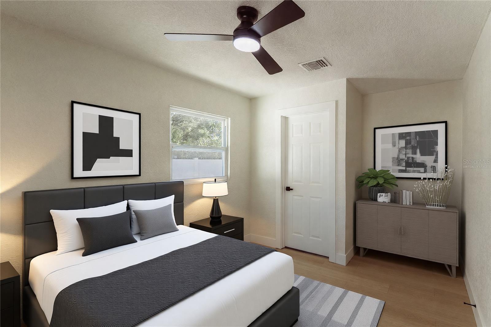The spacious primary bedroom offers warm luxury vinyl flooring, a modern ceiling fan, and a private door leading directly to the en suite bathroom. (Virtually Staged.)
