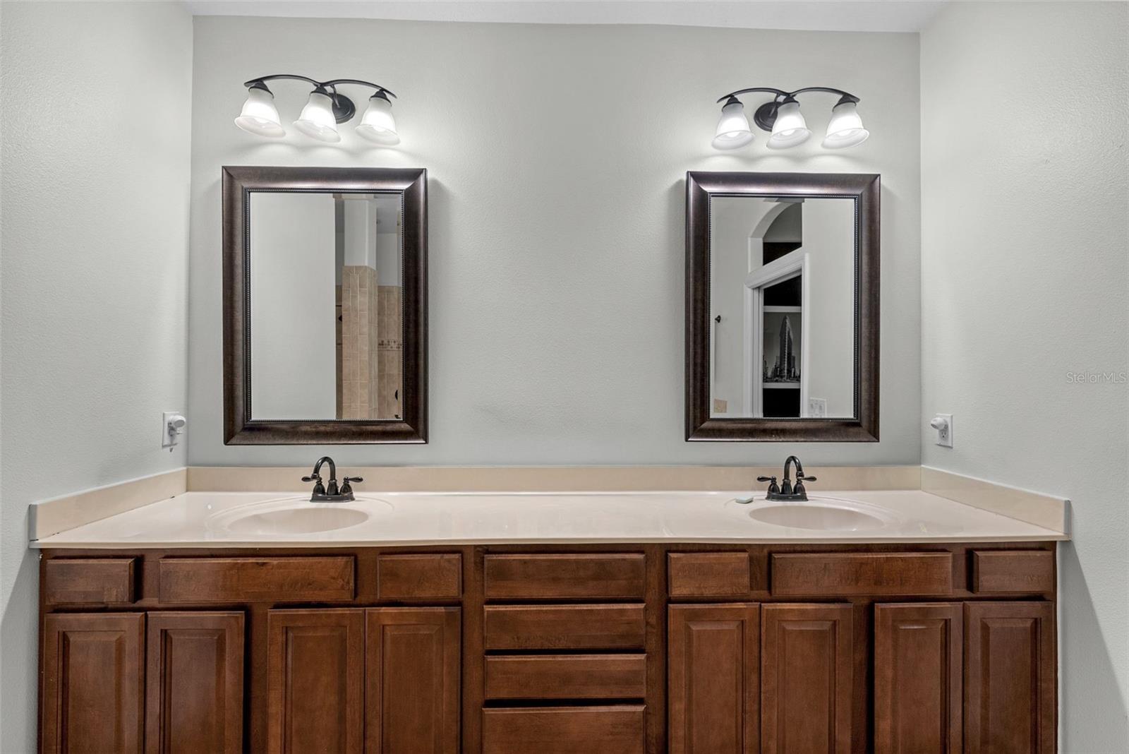 Primary bath with dual sinks and abundant vanity storage.