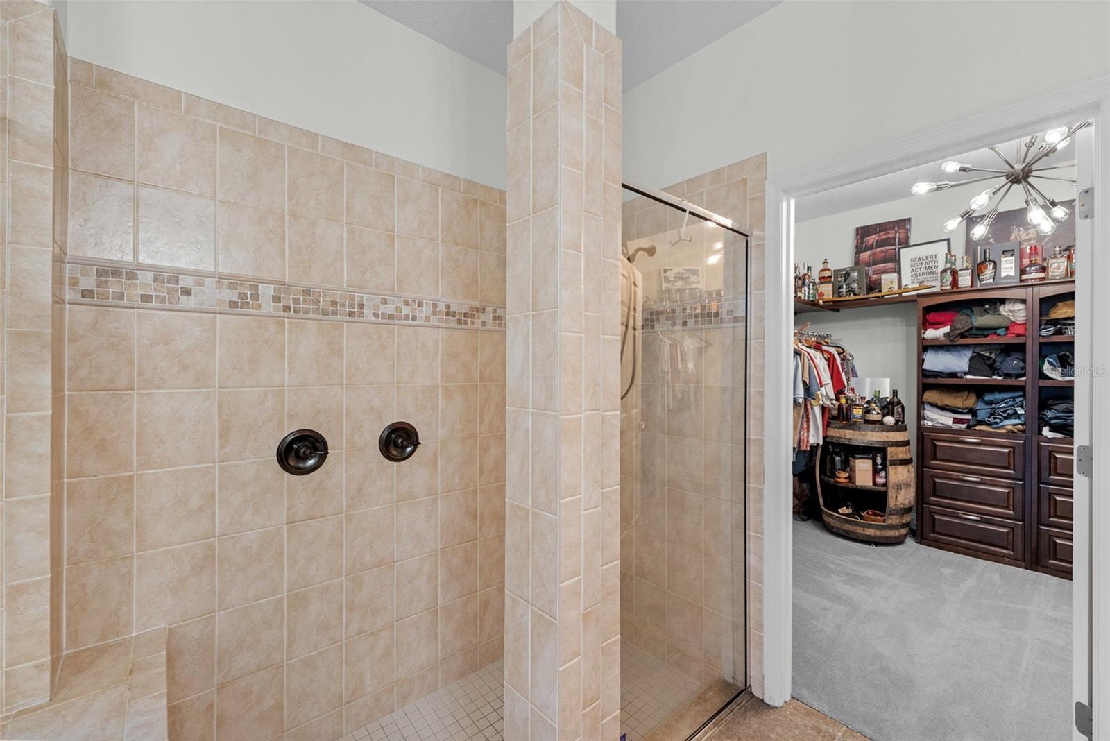 Walk-in shower with neutral tile and spacious design.
