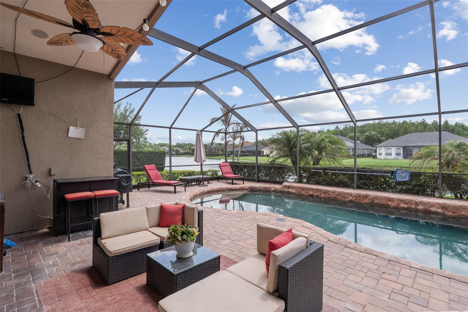 Screened lanai overlooking custom pool, spa, and pond views.