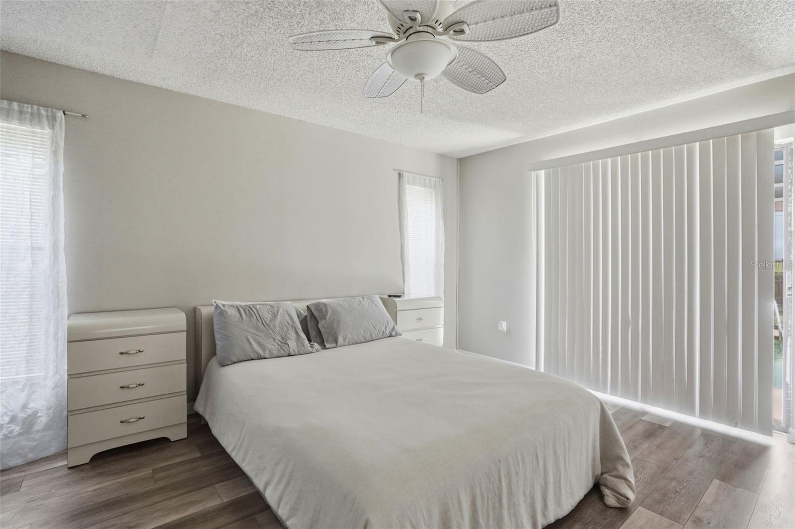 Master bedroom. New luxury vinyl floors, glass sliders to the pool.