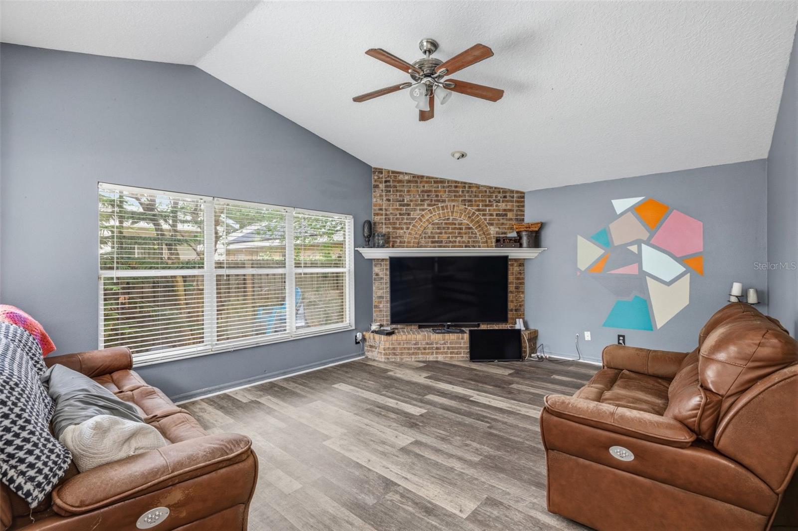 Large family room right off of the kitchen with vaulted ceilings and wood burning fireplace.