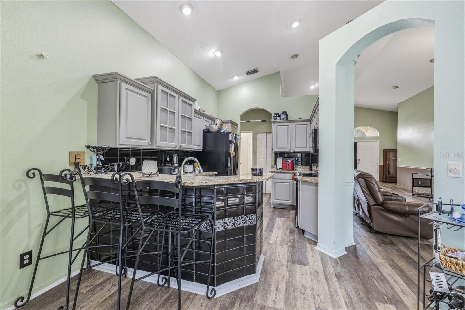 Open kitchen with wood cabinets, granite countertops, recessed lighting and open to the family room and breakfast nook!
