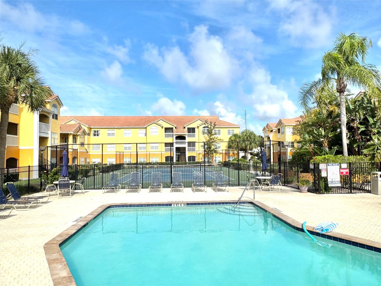 Tennis court beyond the community pool
