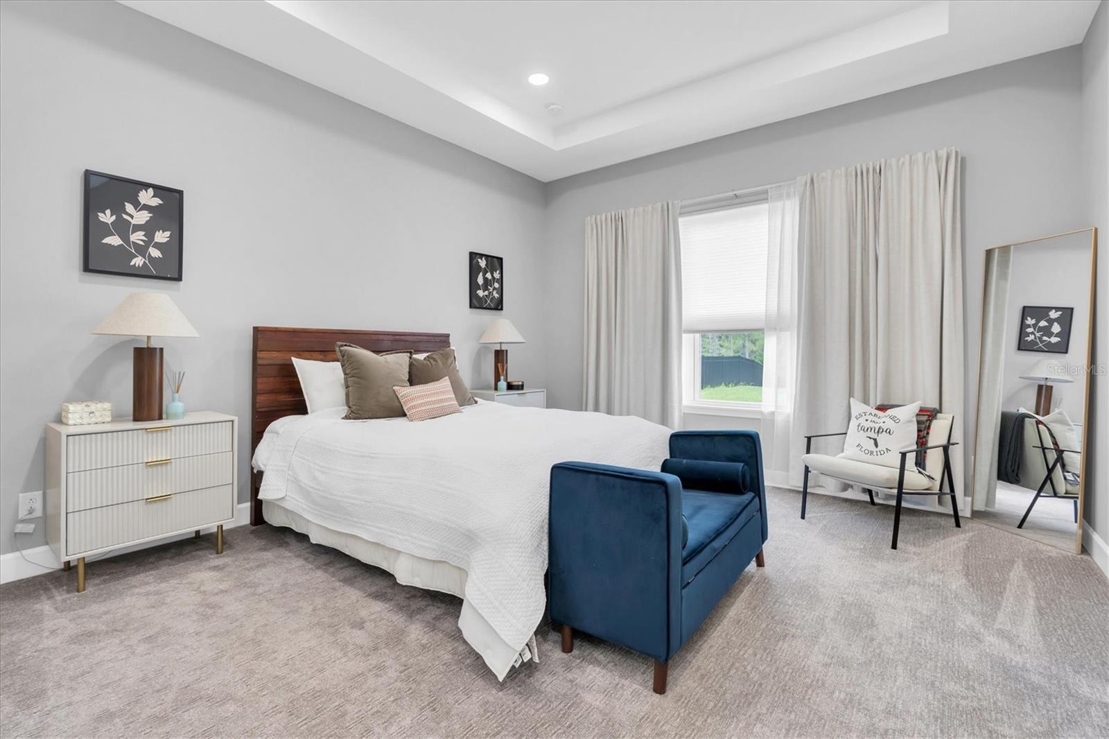 PRIMARY BEDROOM WITH TRAY CEILING AND VIEWS OF THE CONSERVATION