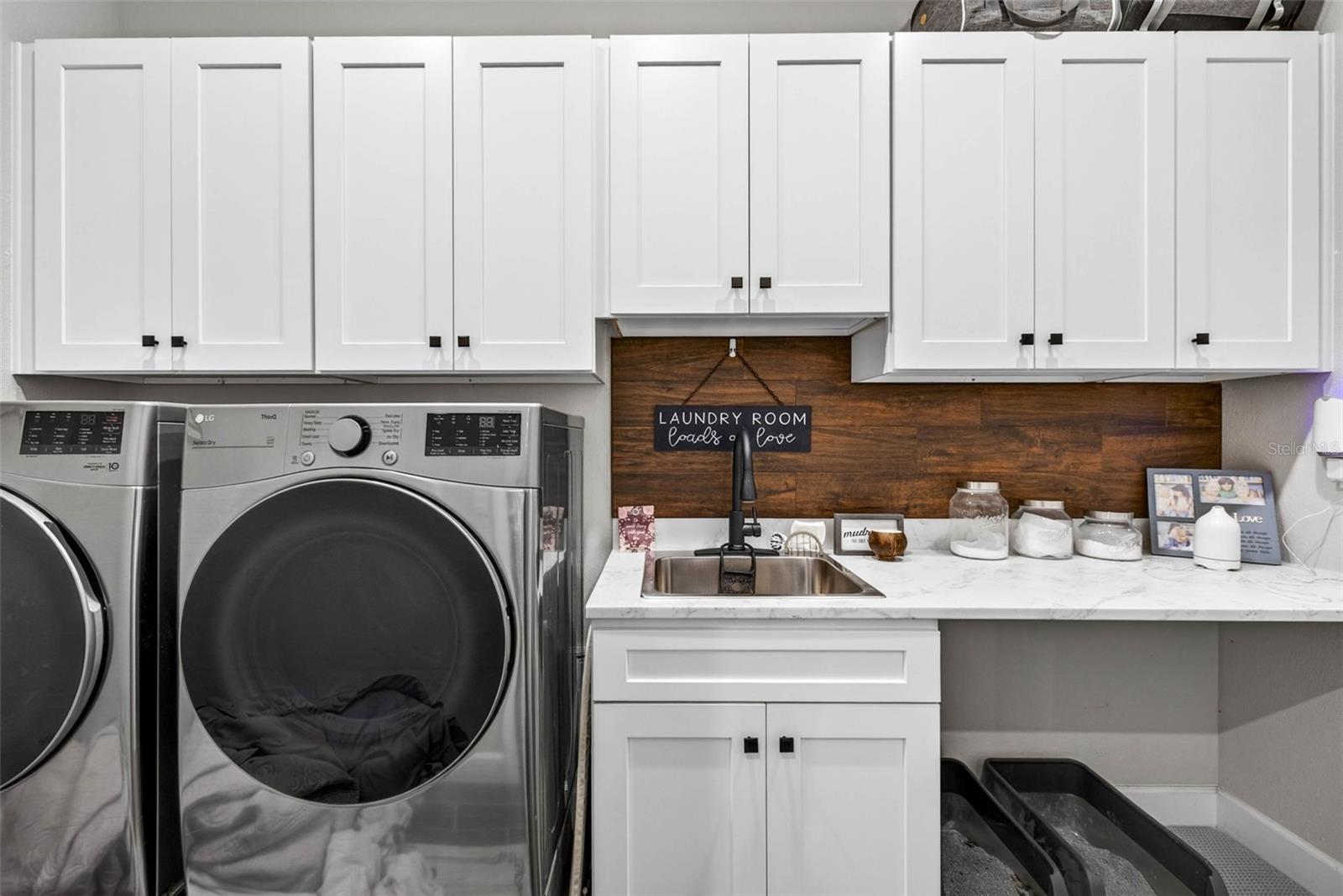 Laundry with additional cabinetry, sink, and folding table.