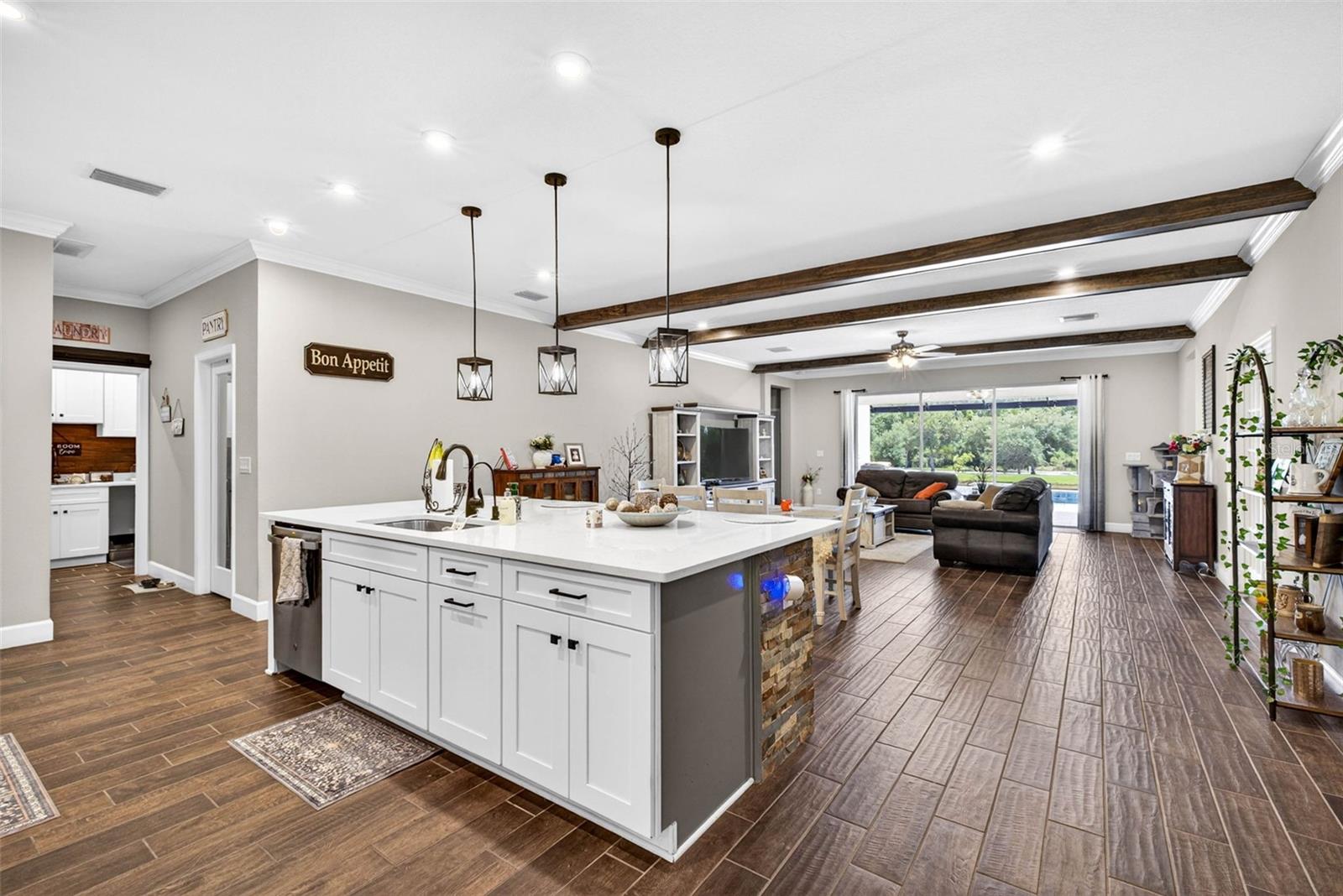 Walnut colored flooring throughout with stunning white cabinetry in the kitchen and dining area.