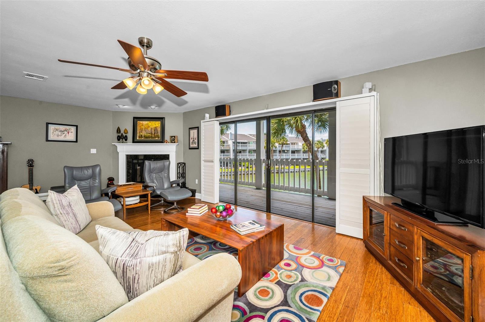 Living room with fireplace, bamboo flooring and sliders to the balcony