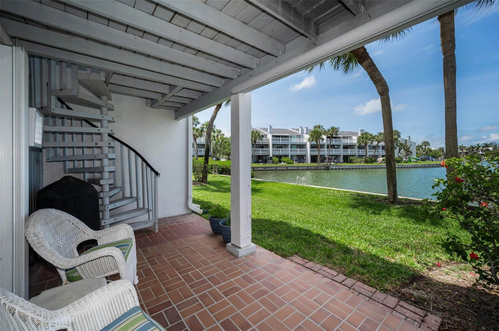 Patio just off the garage with sprial staircase to the upstairs balcony
