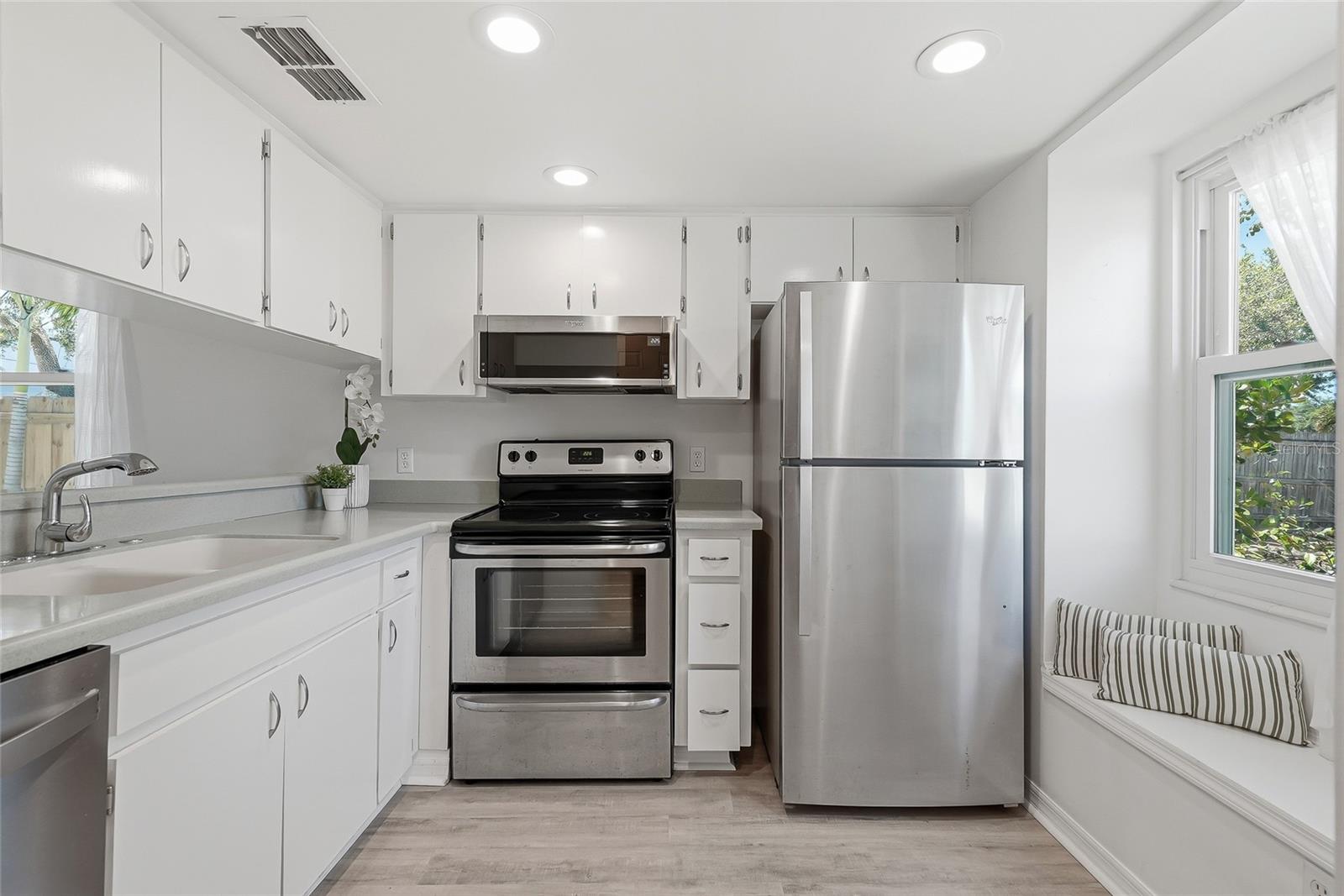 Greeted by a bright kitchen with a seating bench.