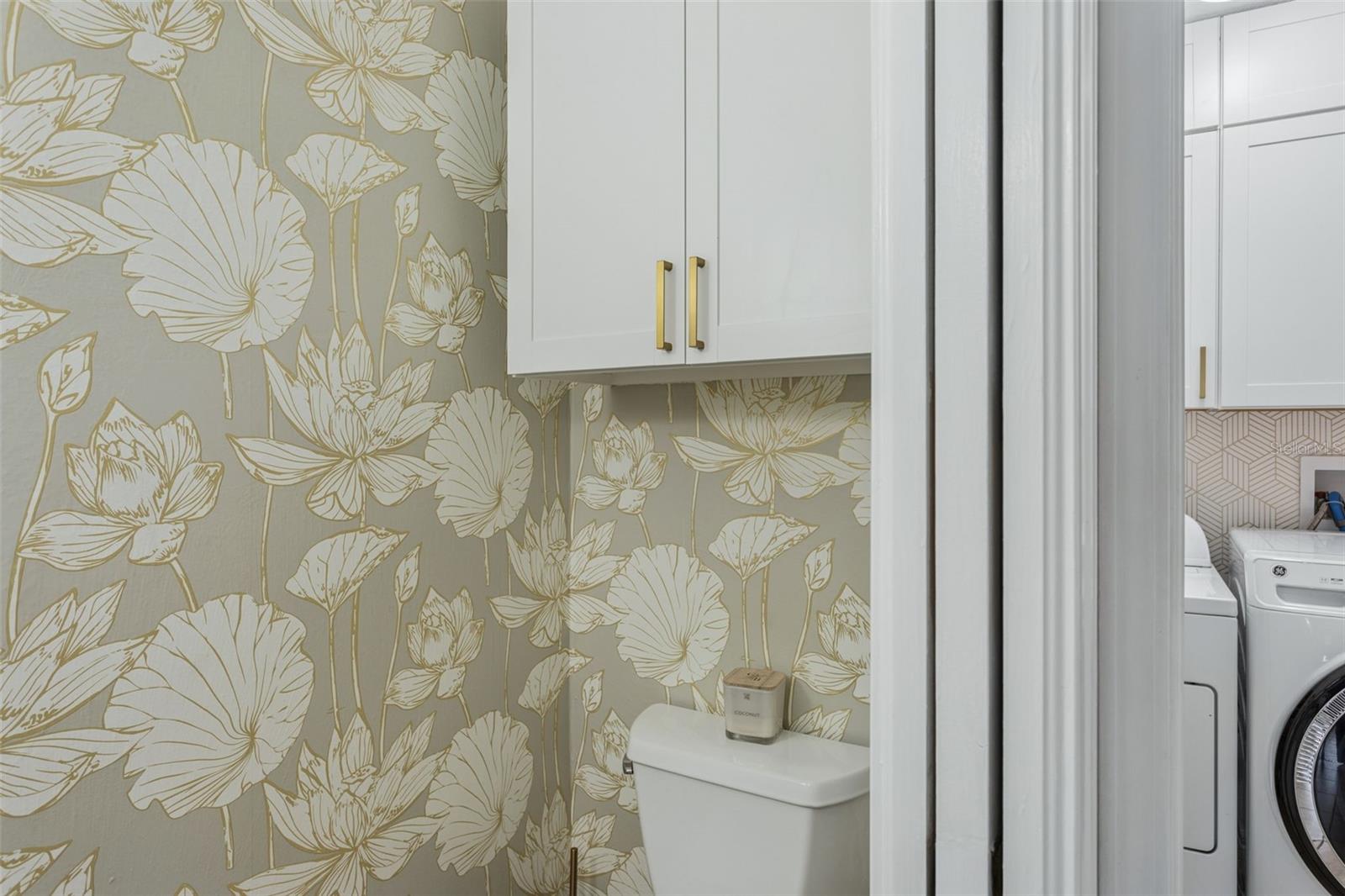 Wallpaper is exquisite and a cabinet over the commode.  Pocket door provides more space.