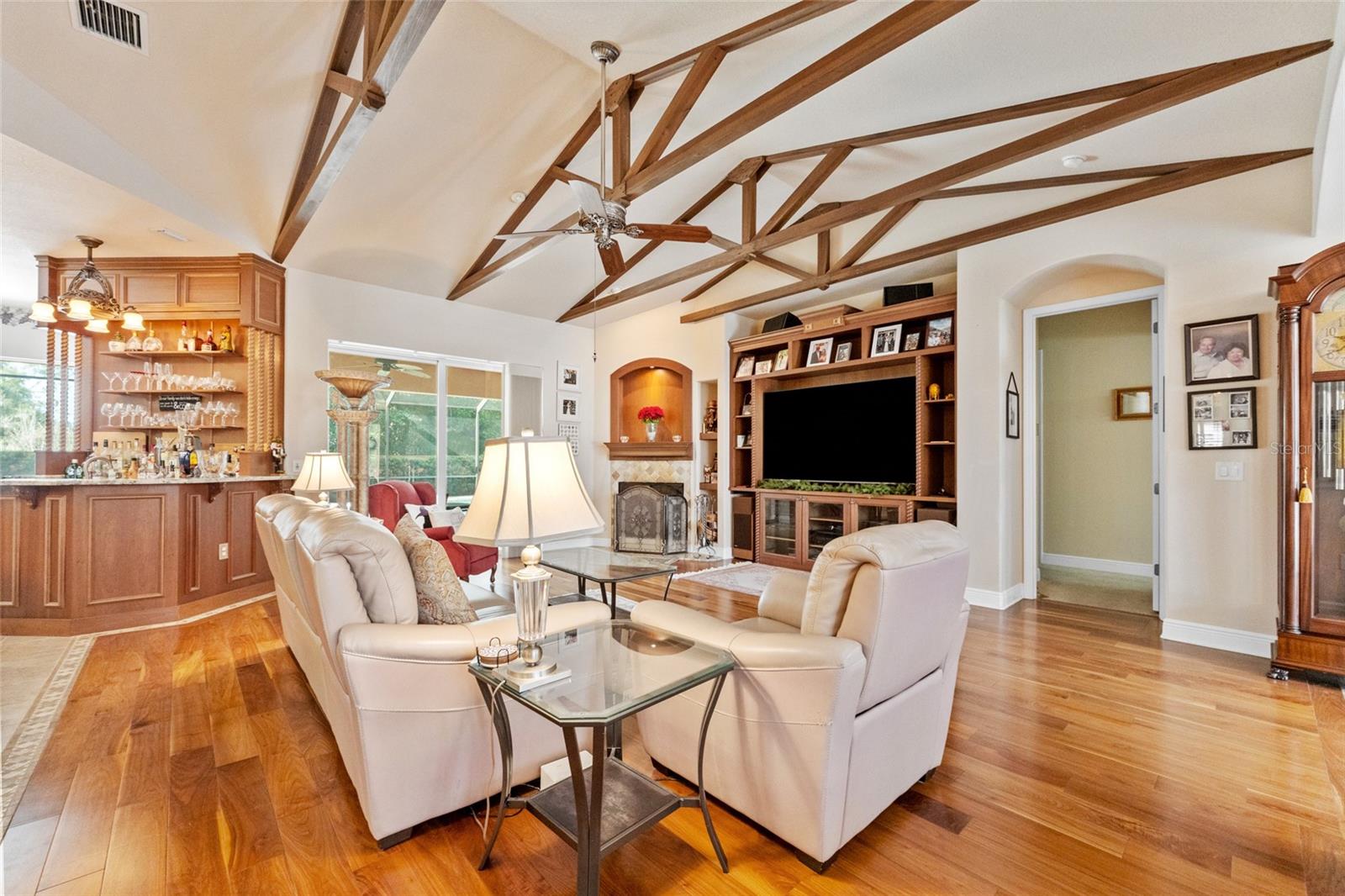 Living area with wood burning fireplace, wet bar and sliding doors to pool area