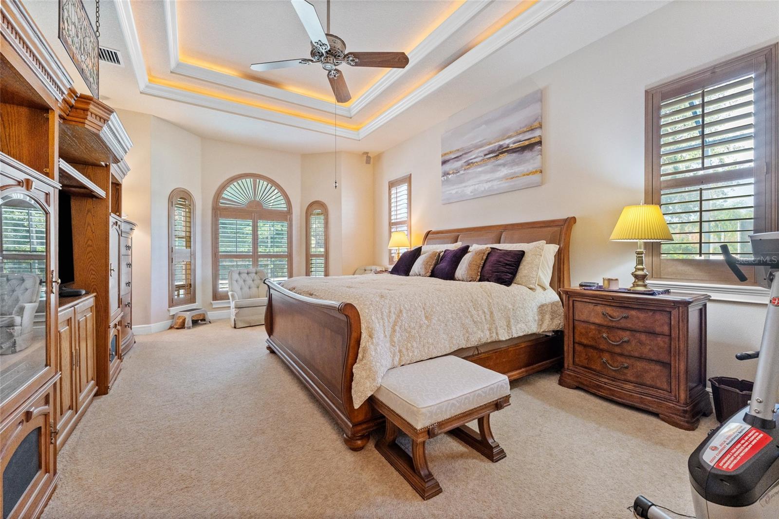 Primary suite with double tray ceiling, bay window, and plantation shutters