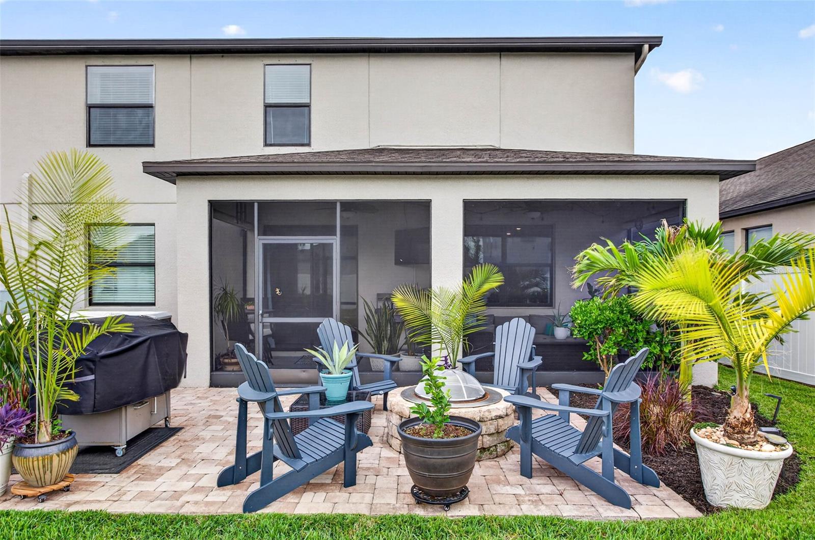 Extended pavered lanai with firepit perfect for Florida style living all year