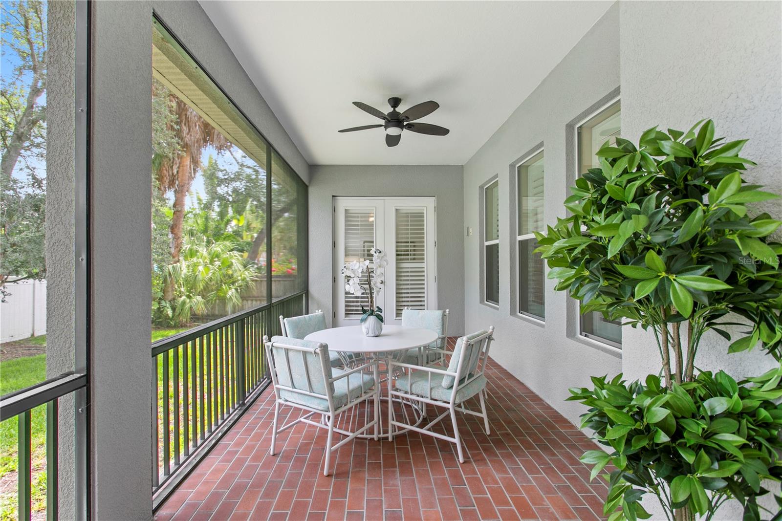 A door opens to the screened lanai, seamlessly extending your living space outdoors and creating the ideal setting for morning coffee, weekend barbecues, or relaxing evenings overlooking the backyard