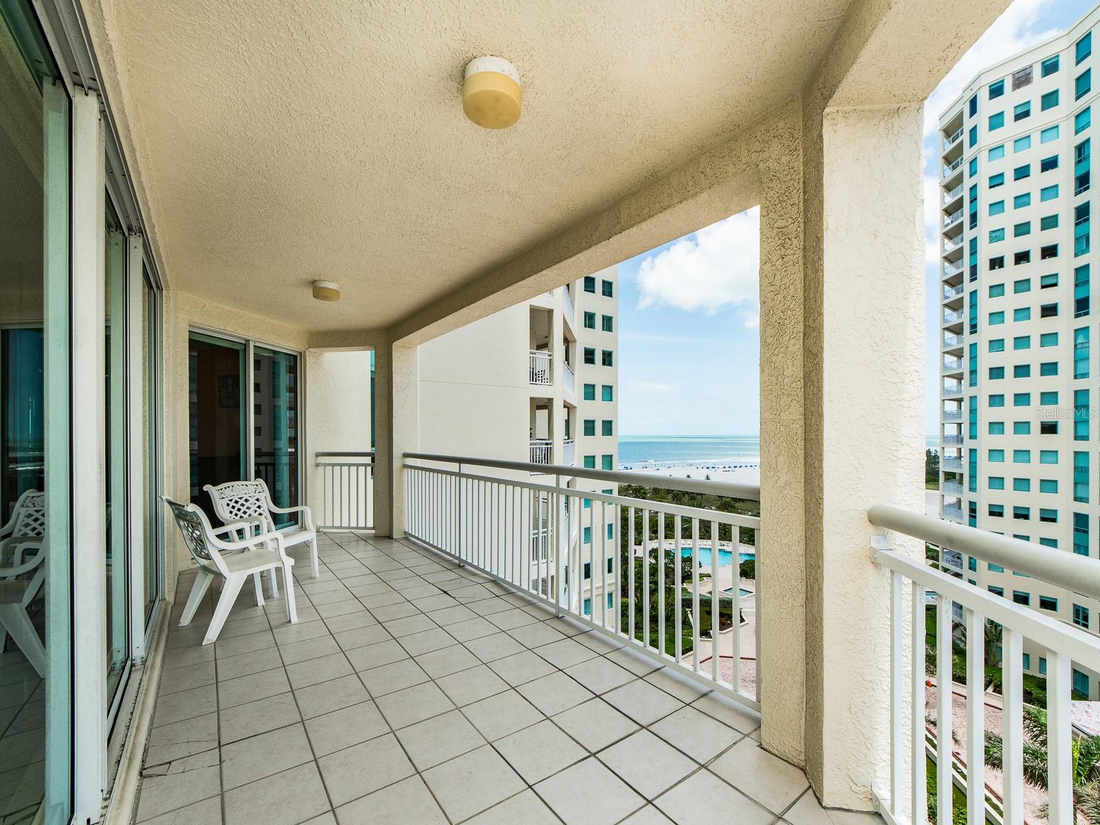 Large balcony spreading from living area, kitchen, and den.