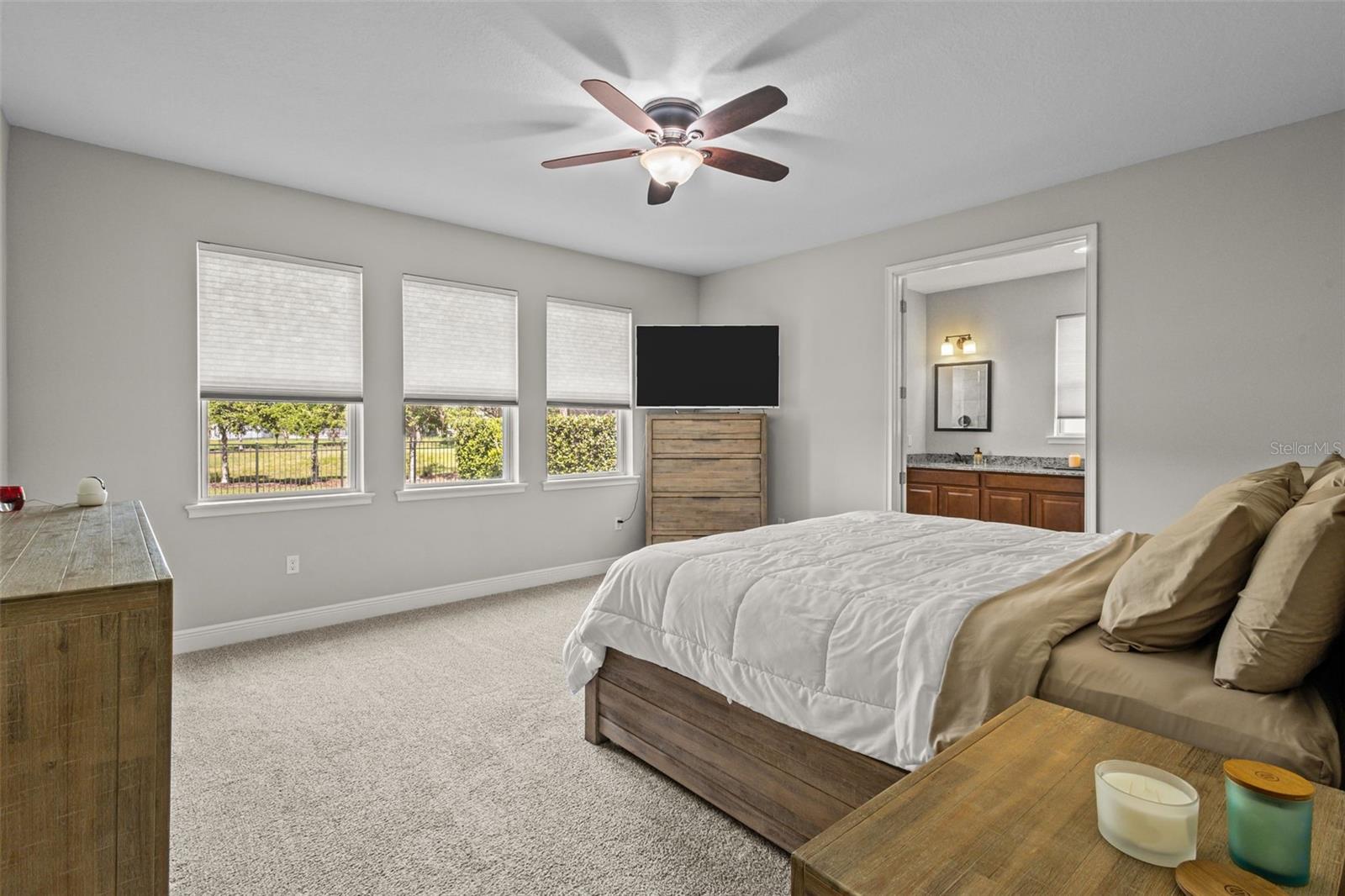 Primary bedroom with peaceful pond-view backdrop