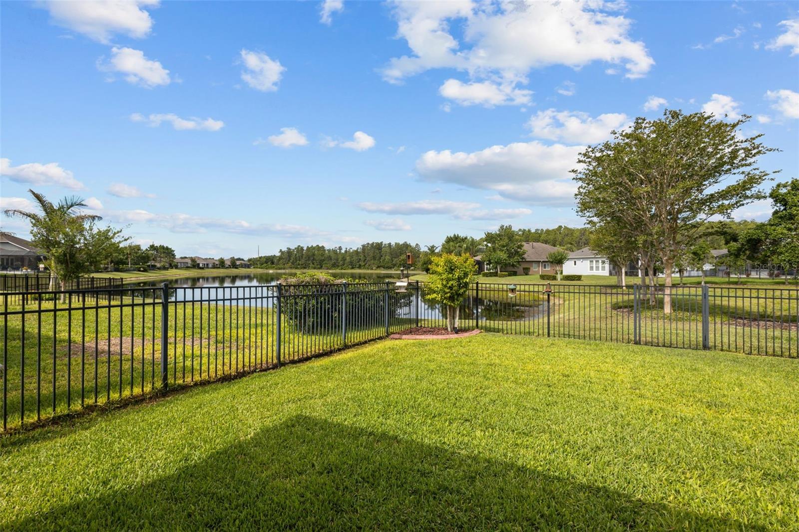 Fenced backyard with serene pond views
