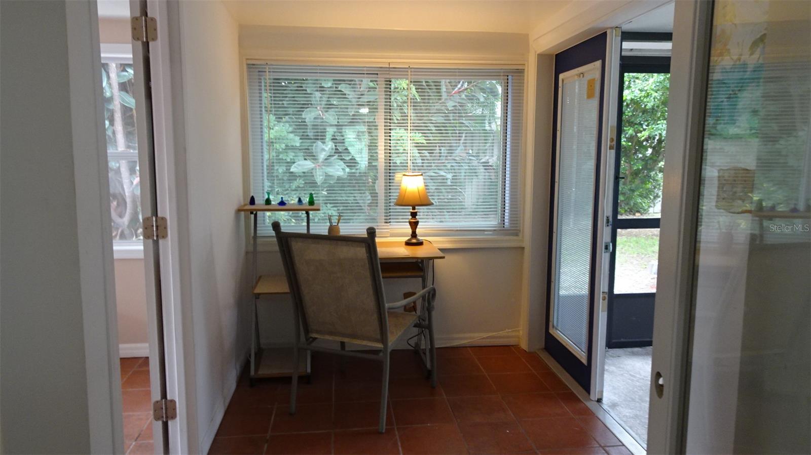 Bonus room, nook with terra cotta tile floors. Double French doors, pella-type leads out to screen enclosed porch.