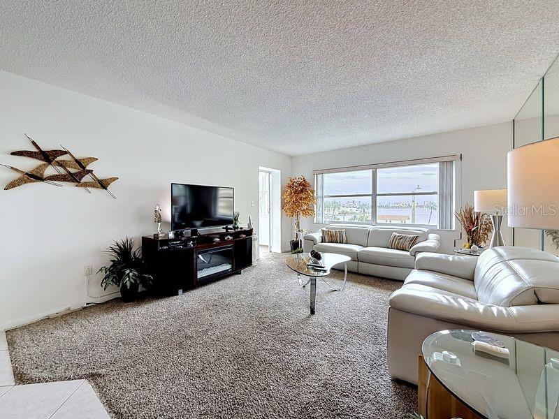 Open and airy living area that flows effortlessly from the dining room, highlighted by contemporary decor and warm sunlight and a serene view.
