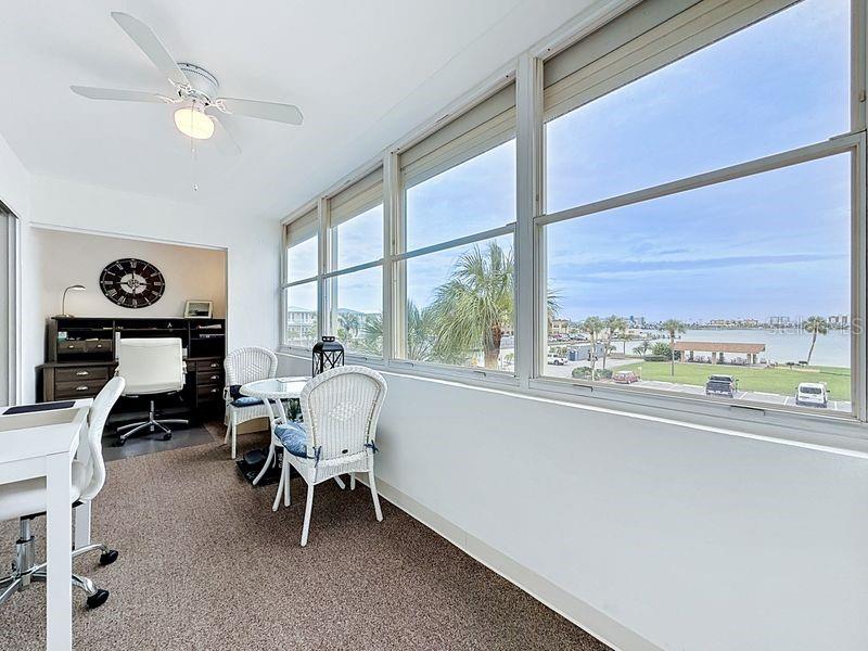 Versatile Florida Room with bright natural light, beautiful intercoastal views, and sliding glass doors- perfect for relaxing or working from home.