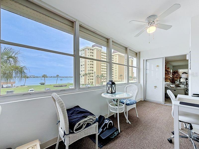 Versatile Florida Room with bright natural light, beautiful intercoastal views, and sliding glass doors- perfect for relaxing or working from home.