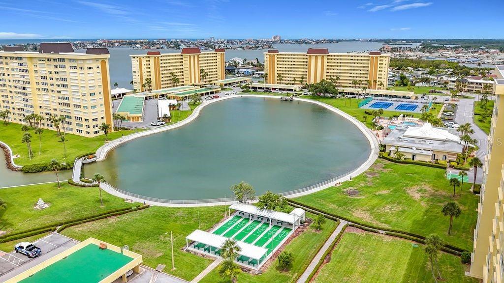 Resort-style community view featuring the Washington building, tennis and pickleball courts, and sparkling pool- all nestled around the tranquil bayou