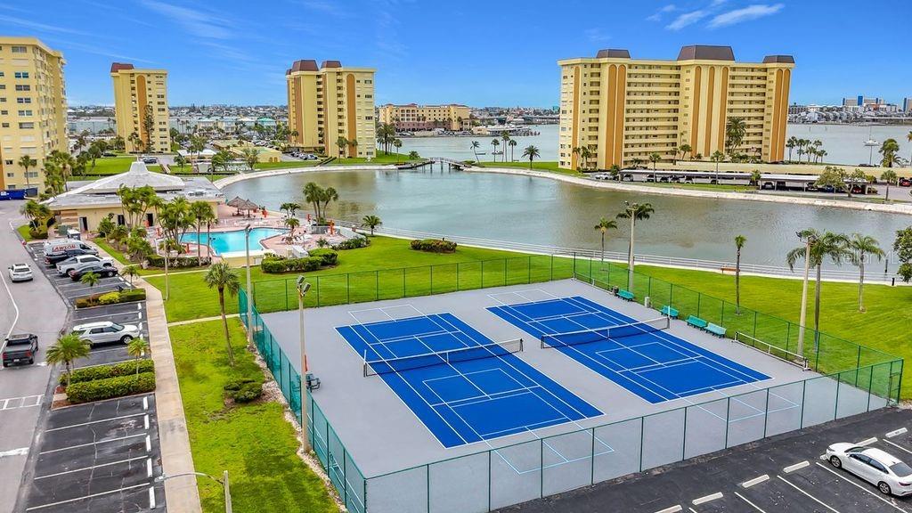 Resort-style community view featuring the Washington building, tennis and pickleball courts, and sparkling pool- all nestled around the tranquil bayou