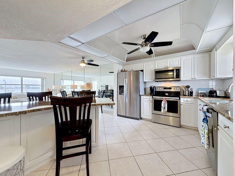 As you enter, you will see the spacious chef's kitchen with gleaming stainless steel appliances, crisp white cabinetry, and a breakfast nook bathed in natural light.