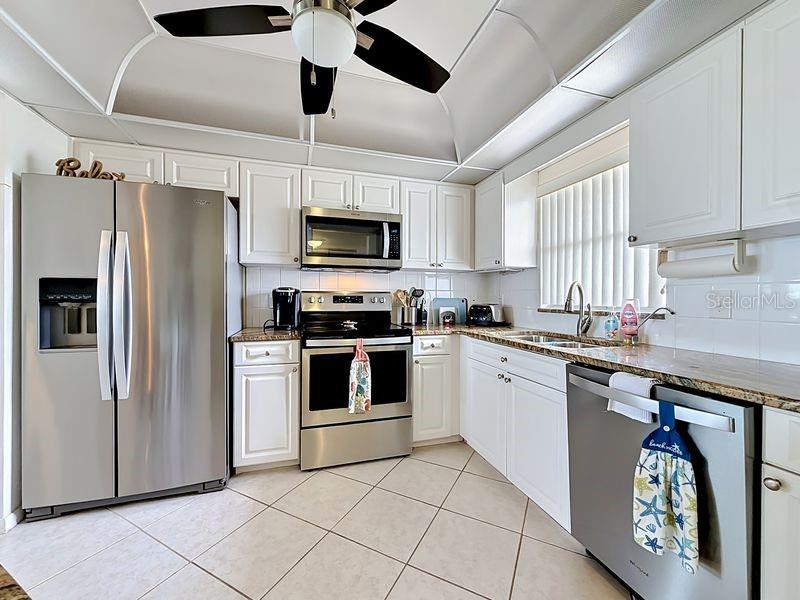 Modern coastal charm kitchen with tile floors, sleek finishes, and a layout that flows endlessly for entertaining.