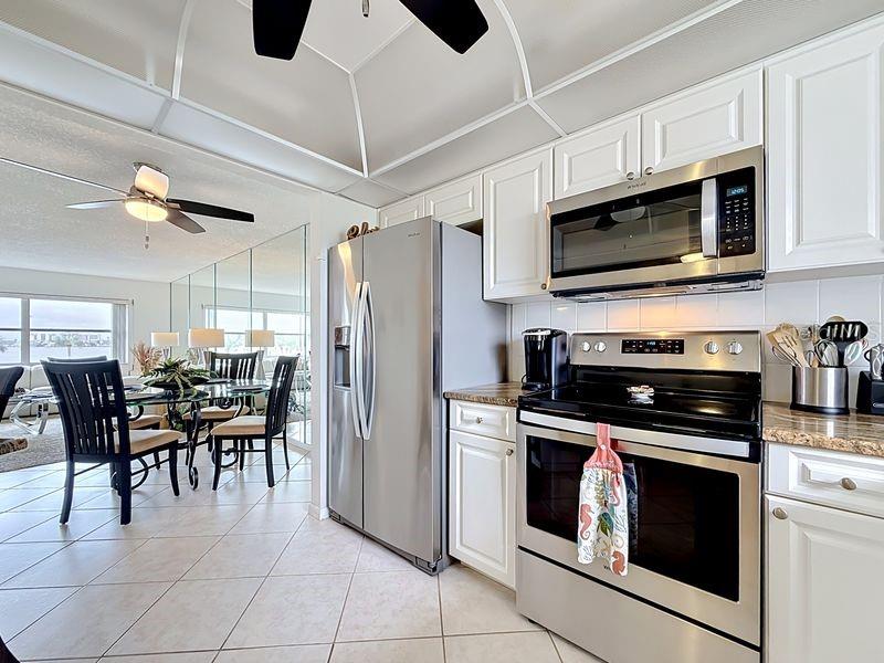 Modern coastal charm kitchen with tile floors, sleek finishes, and a layout that flows endlessly for entertaining.