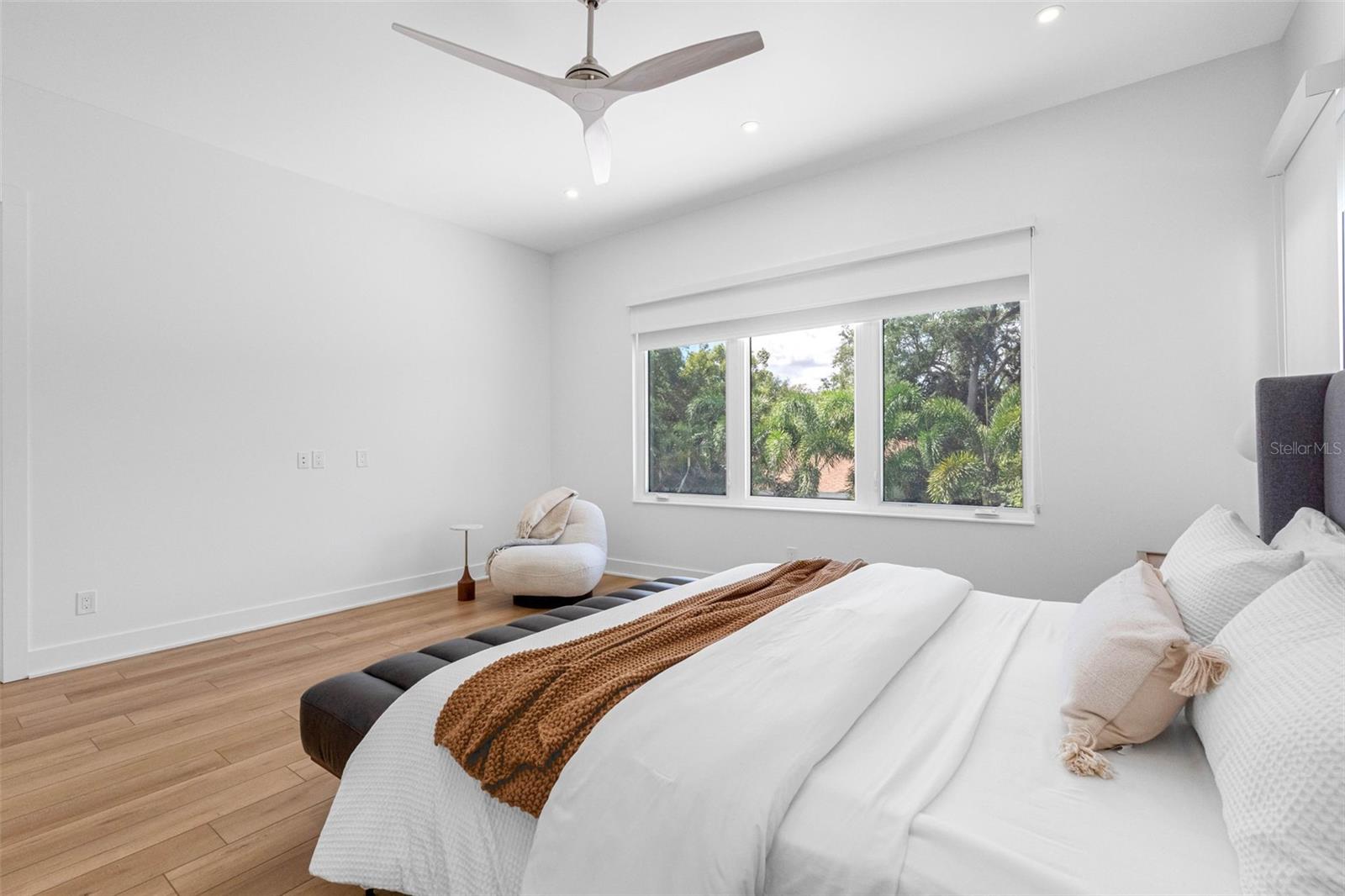 nch doors open to the ample master bedroom featuring his and hers walk-in closets with built-ins, dimmable lights, window treatment and Minka ceiling fan, known for their quiet operation and distinctive style