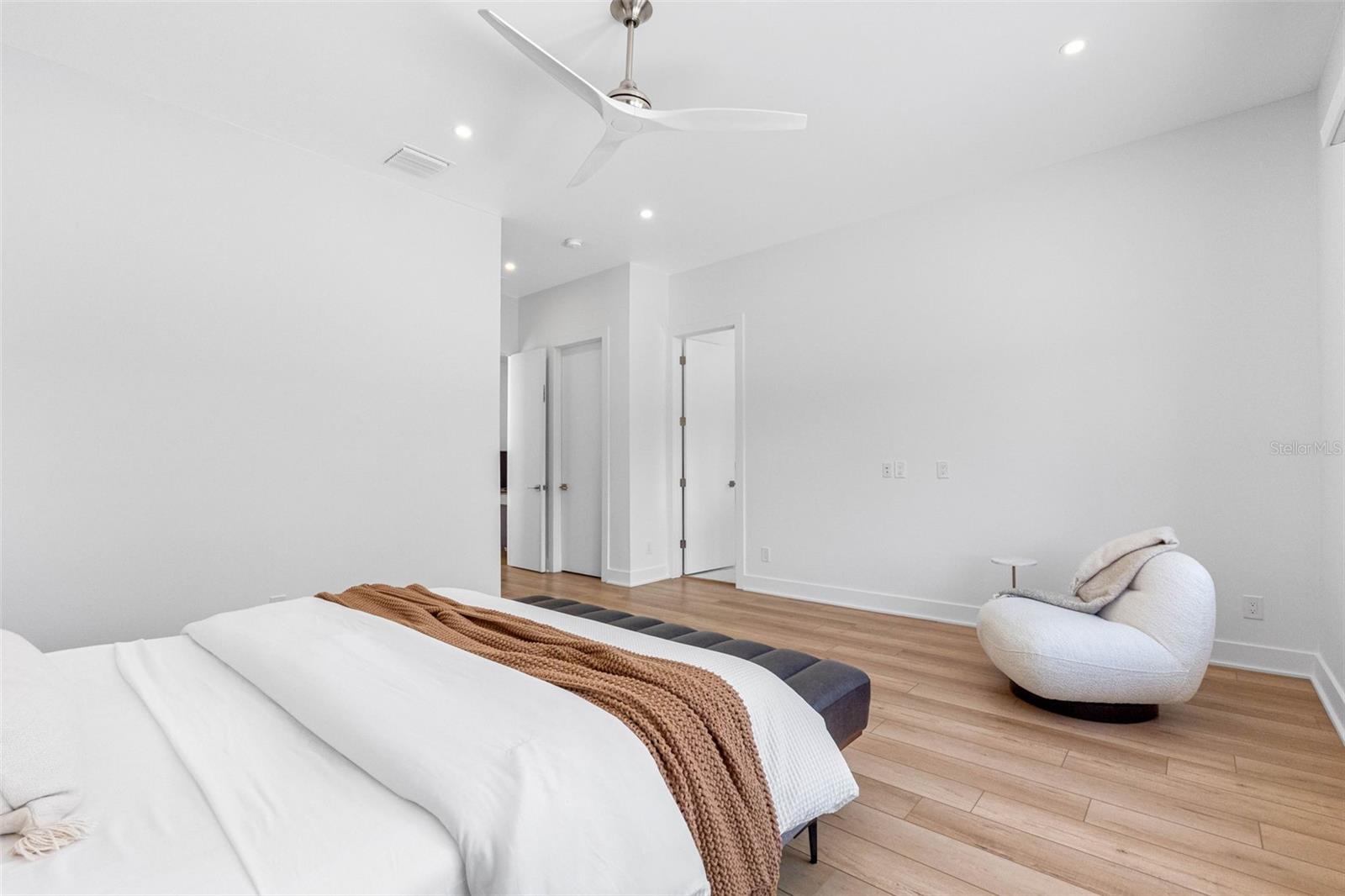 nch doors open to the ample master bedroom featuring his and hers walk-in closets with built-ins, dimmable lights, window treatment and Minka ceiling fan, known for their quiet operation and distinctive style