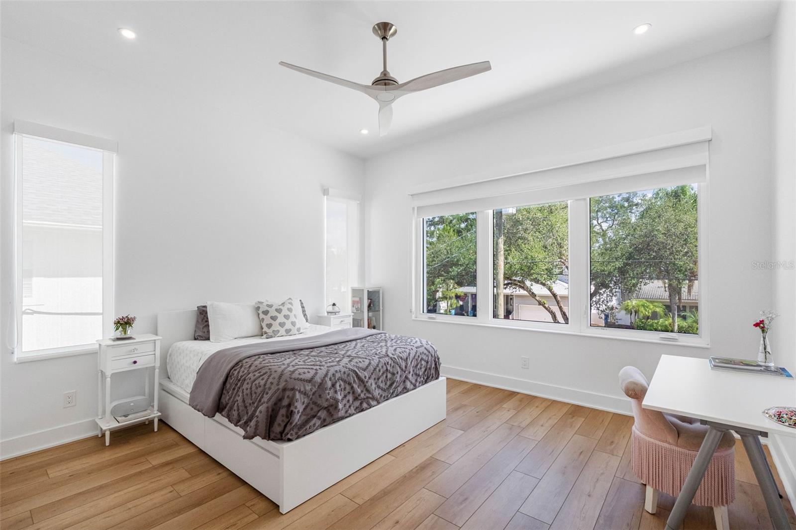 Bedroom 2 boasts en-suite bath with glass-enclosed shower, closest system, window treatment, dimmable lights, and Minka ceiling fan, known for their quiet operation and distinctive style