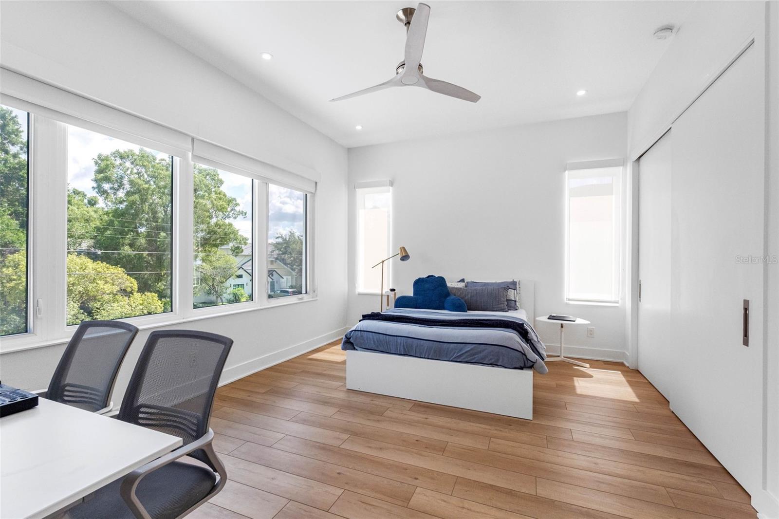 Bedroom 3 boasts en-suite bath with glass-enclosed shower, closet system, window treatment, dimmable lights, and Minka ceiling fan, known for their quiet operation and distinctive style