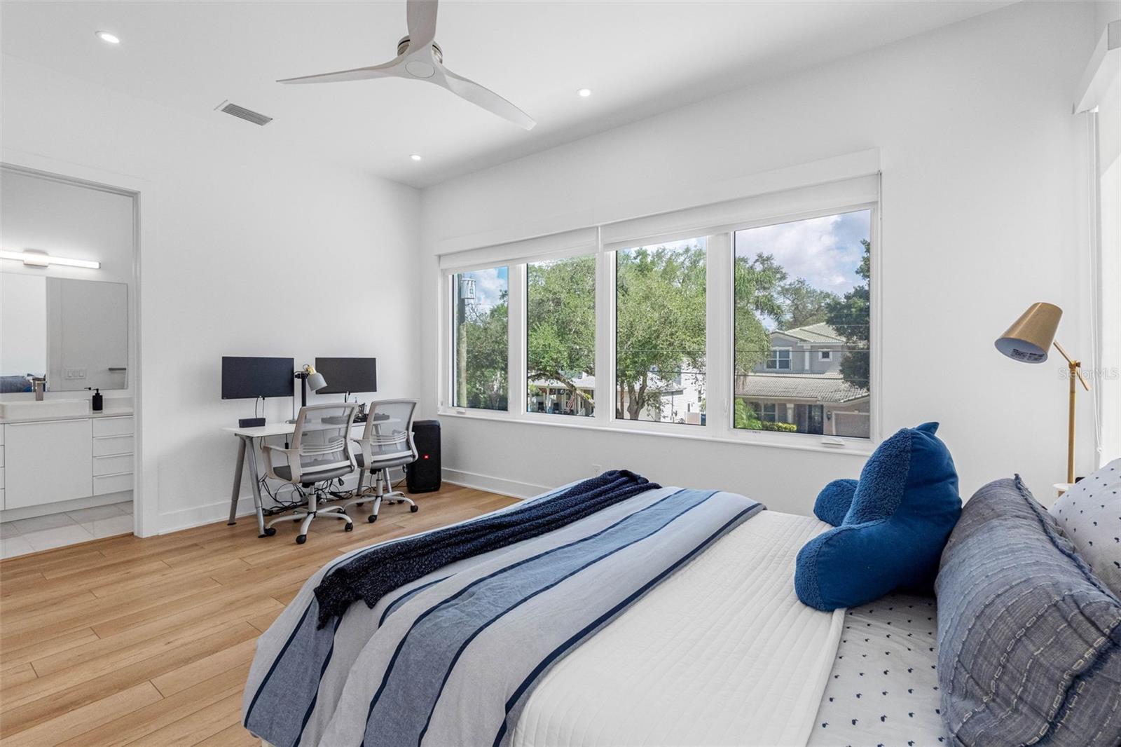 Bedroom 3 boasts en-suite bath with glass-enclosed shower, closet system, window treatment, dimmable lights, and Minka ceiling fan, known for their quiet operation and distinctive style