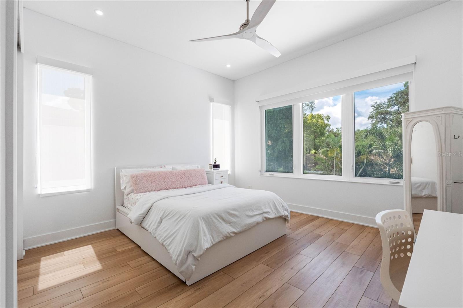 Bedroom 4 boasts en-suite bath with glass-enclosed shower, closet system, window treatment, dimmable lights, and Minka ceiling fan, known for their quiet operation and distinctive style