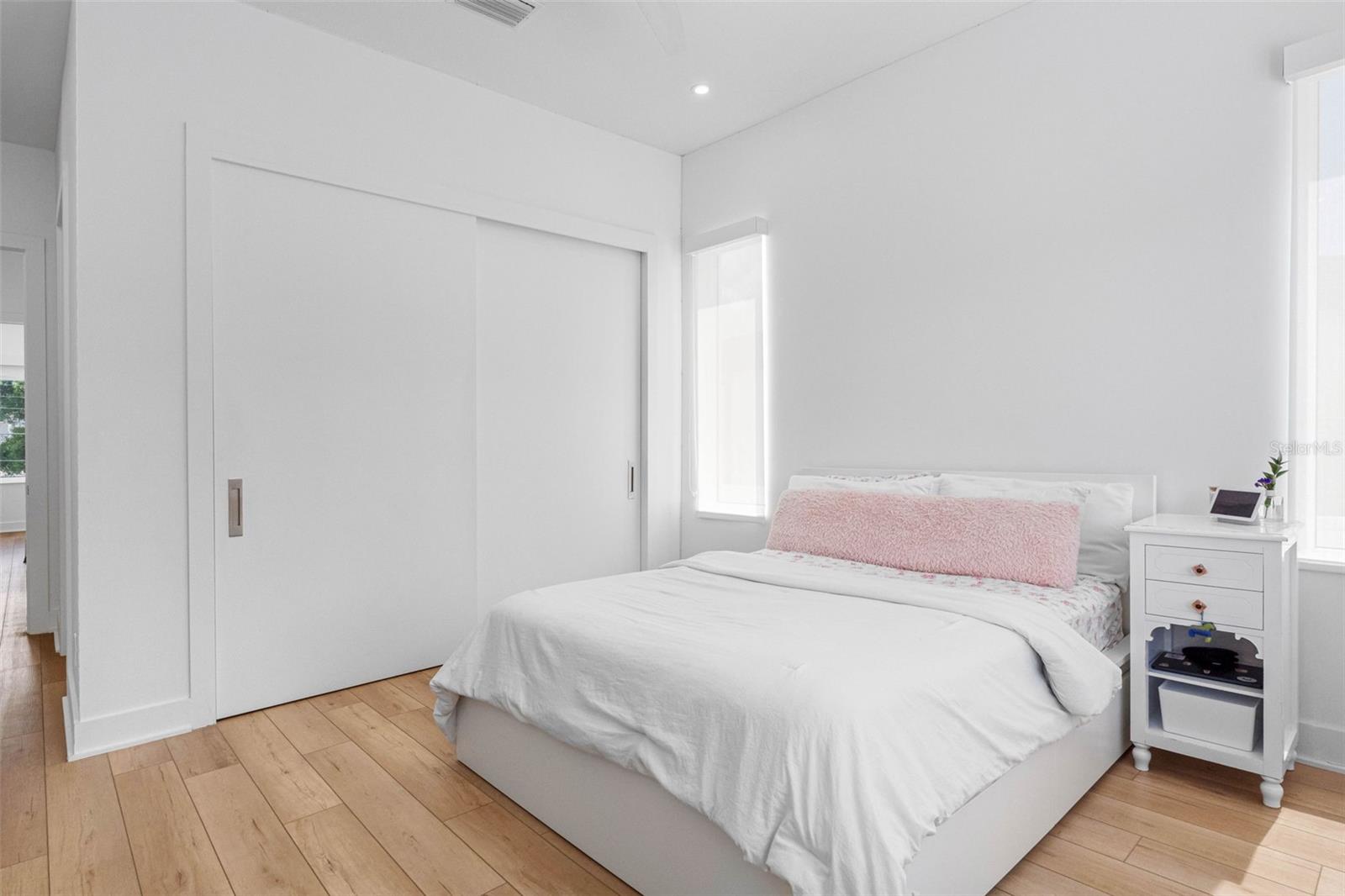 Bedroom 4 boasts en-suite bath with glass-enclosed shower, closet system, window treatment, dimmable lights, and Minka ceiling fan, known for their quiet operation and distinctive style