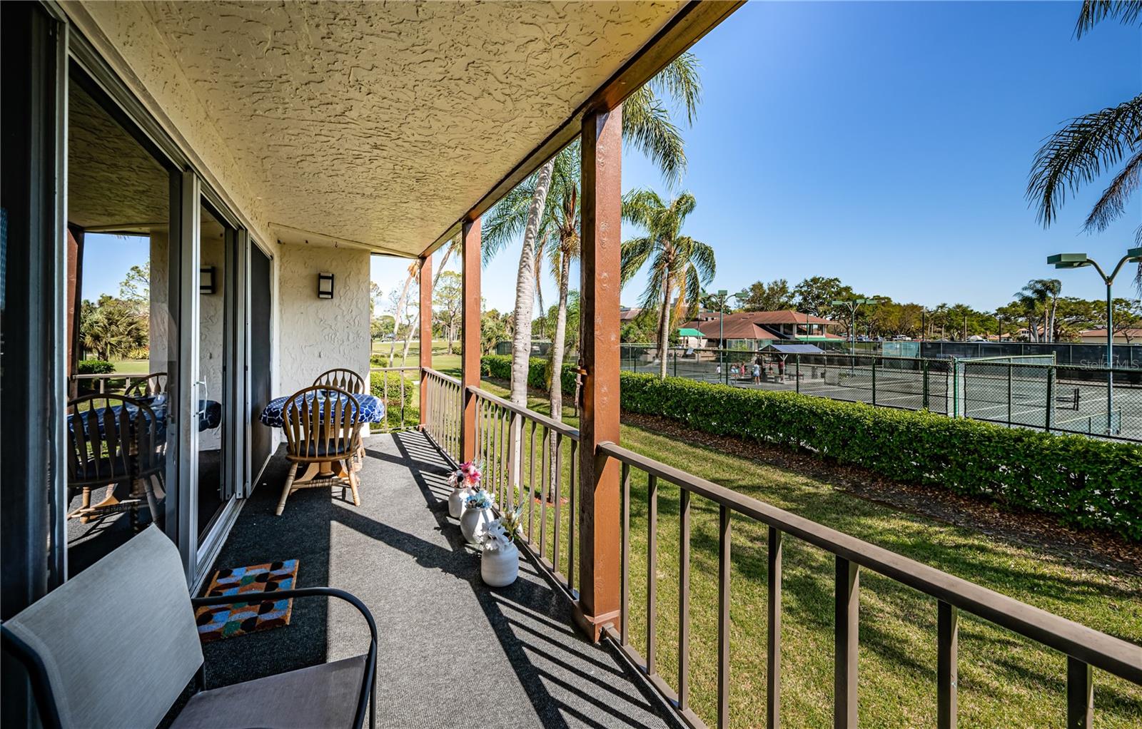 Sunny open balcony with tennis court views