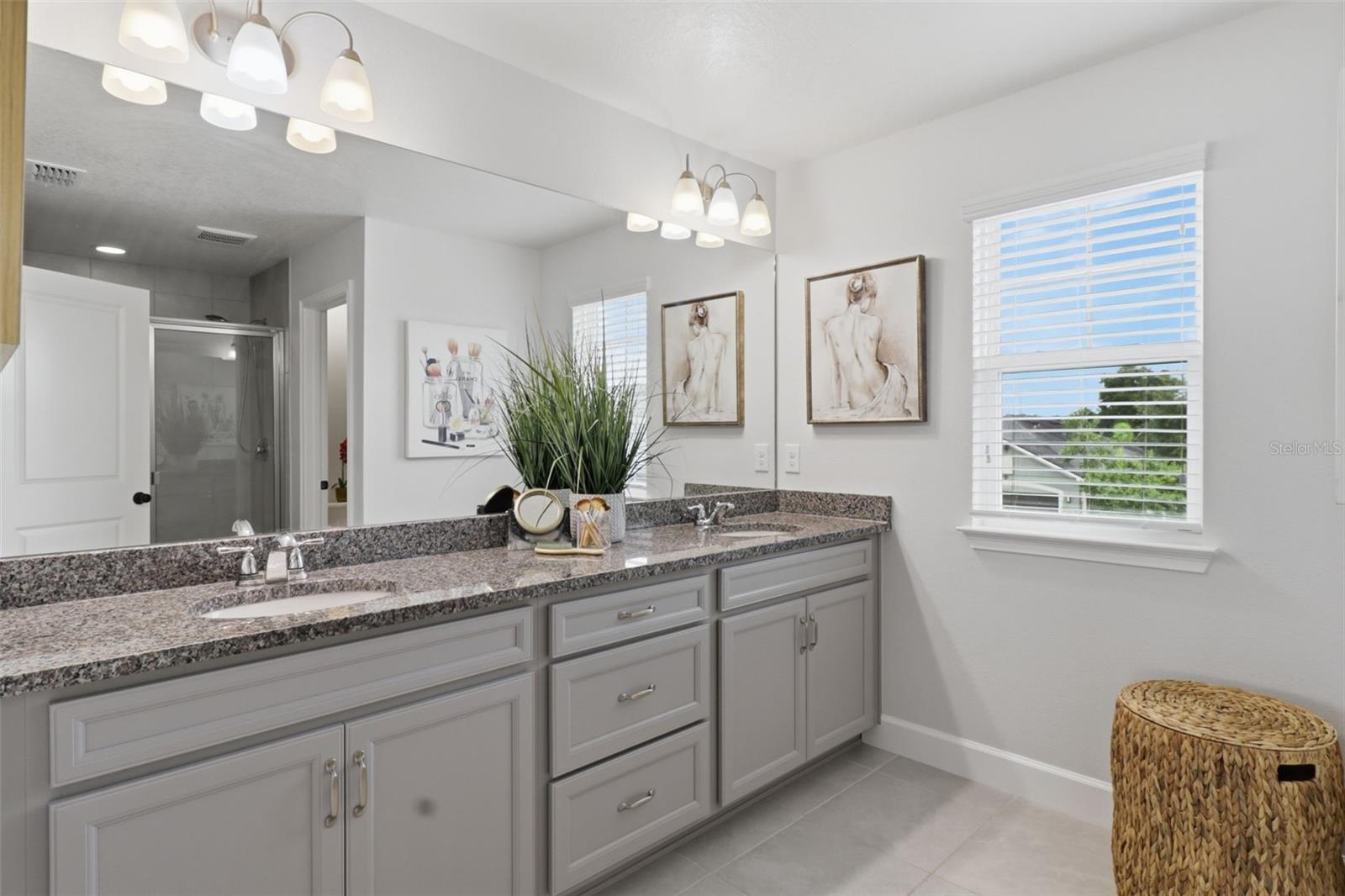 The spacious primary en-suite features dual sinks, a generous vanity, and a walk-in shower, offering both comfort and functionality.