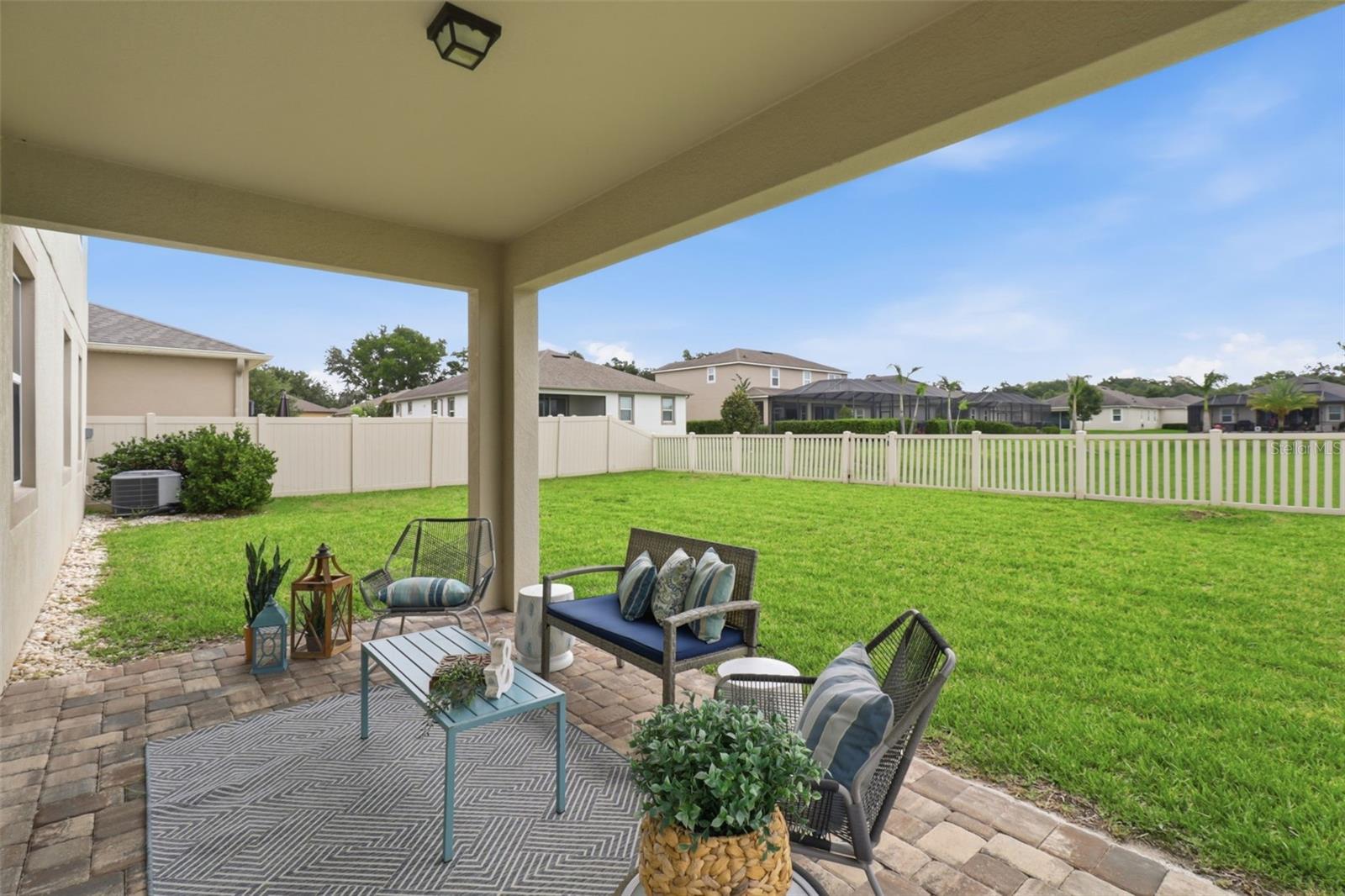 Enjoy Florida living from the pavered patio, offering shade, privacy, and peaceful views of the expansive backyard with no rear neighbors.