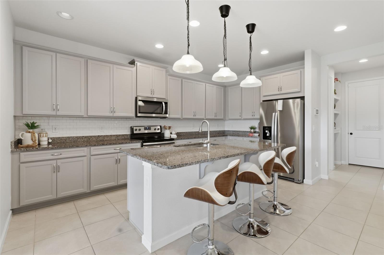 The heart of the home is the spacious kitchen, complete with a breakfast bar, breakfast nook, and abundant cabinet storage.