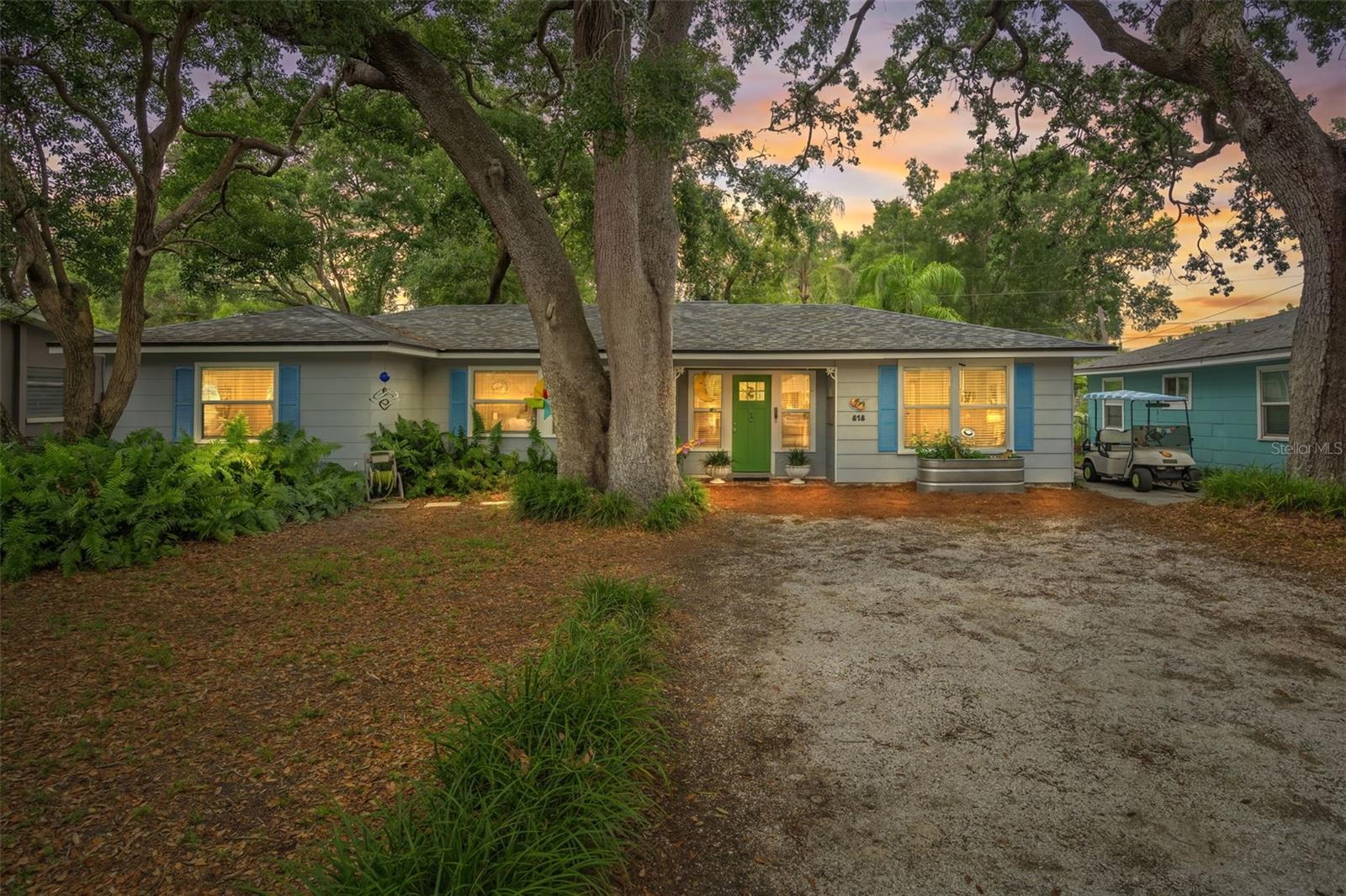 Hidden gem!  Virtually enhanced twilight photo front exterior of home & driveway with parking pad for golf cart.