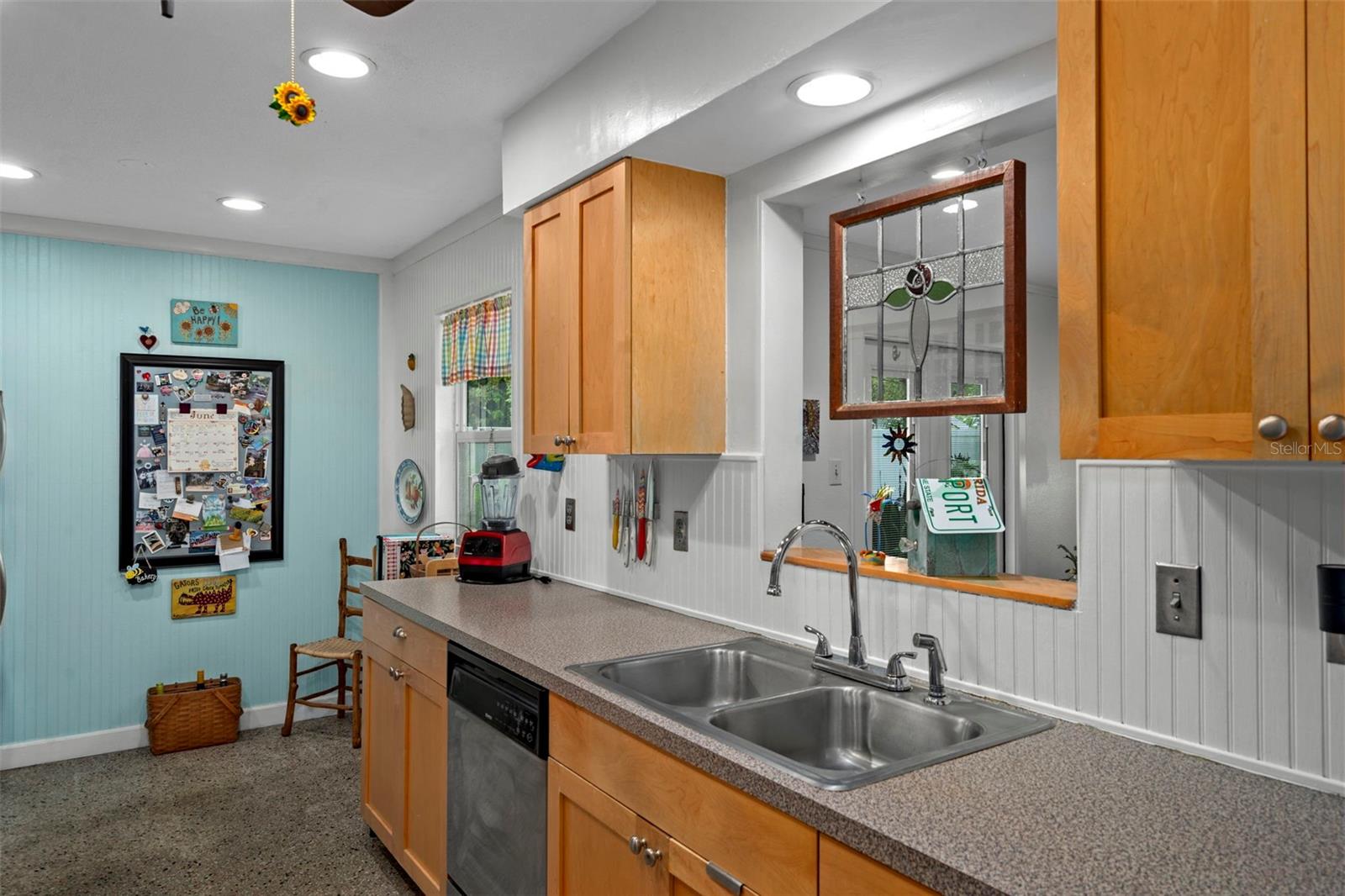 Updated kitchen features wood cabinets and beadboard backsplash.  Natural light enters through the window at the back