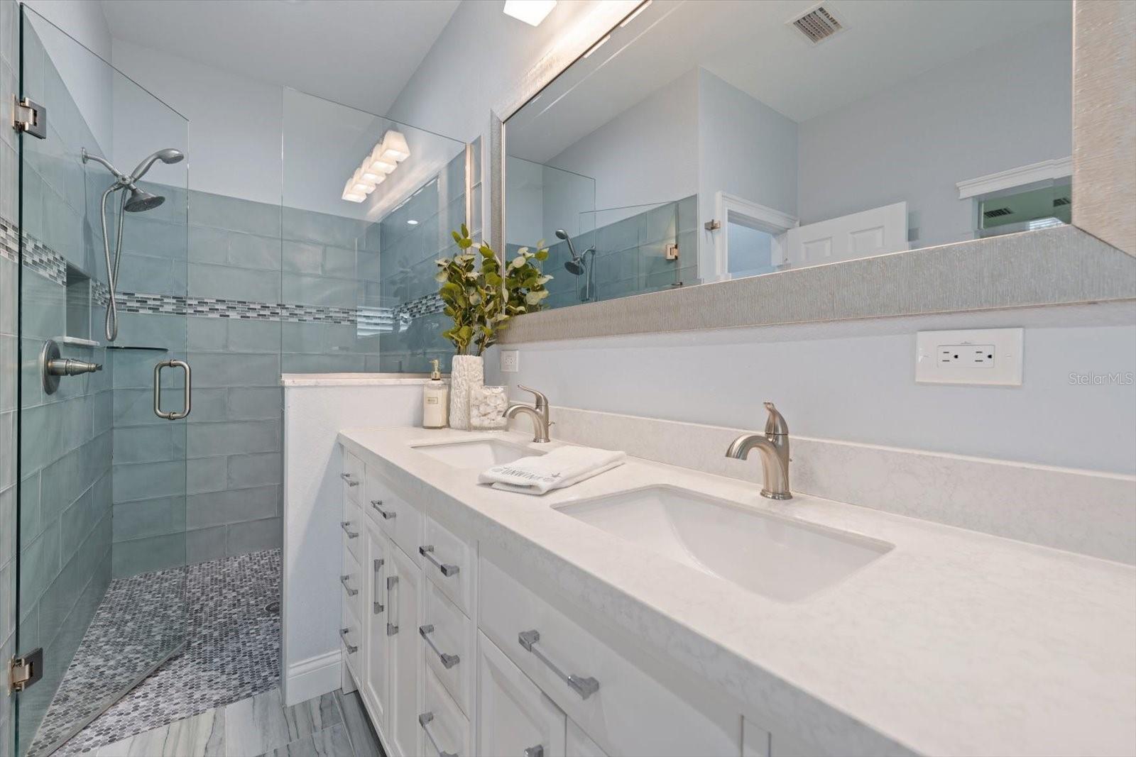 Spa like primary bath with walk in shower and attractive finishings