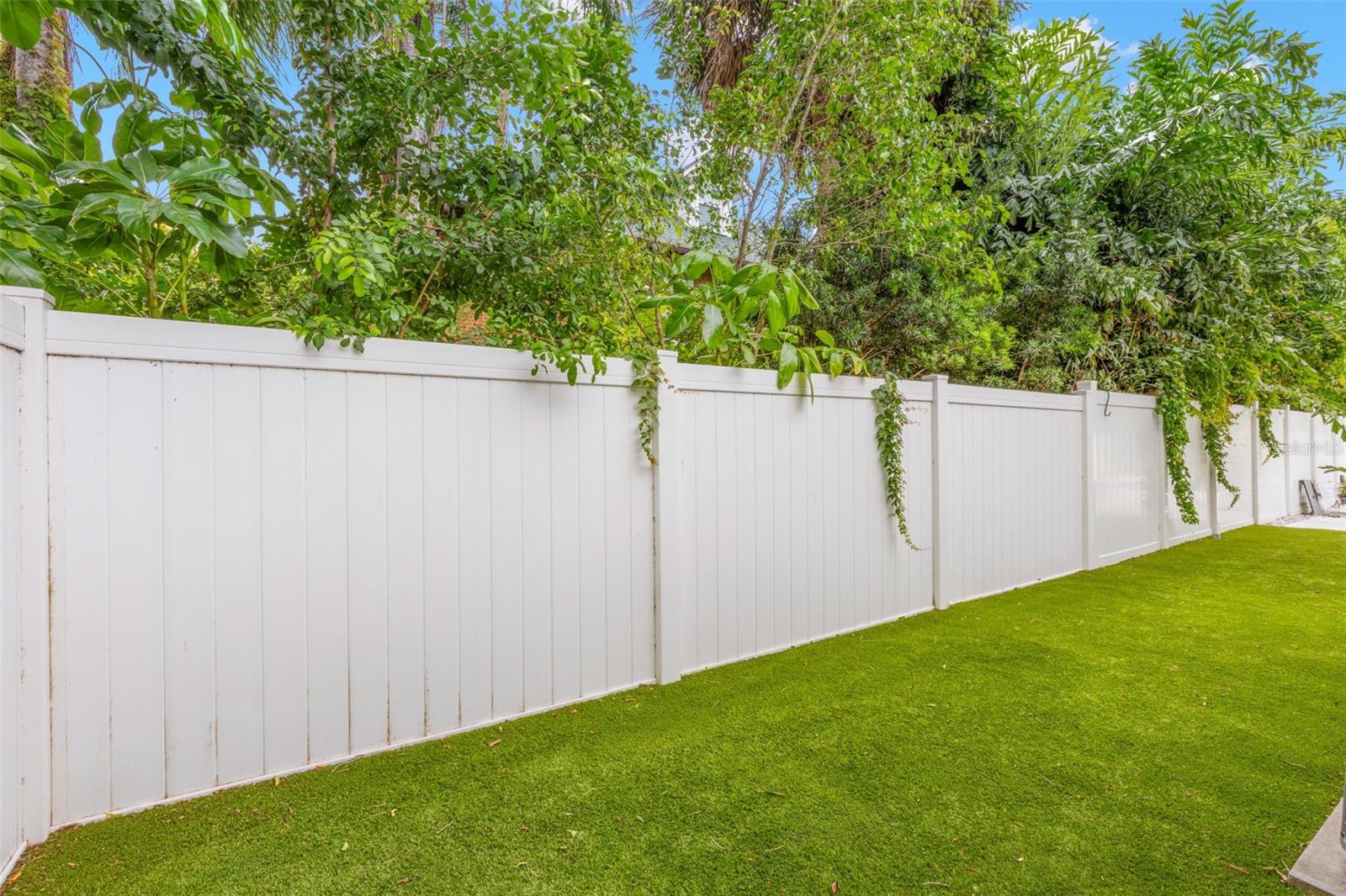 Side yard with artificial turf perfect for a dog run!