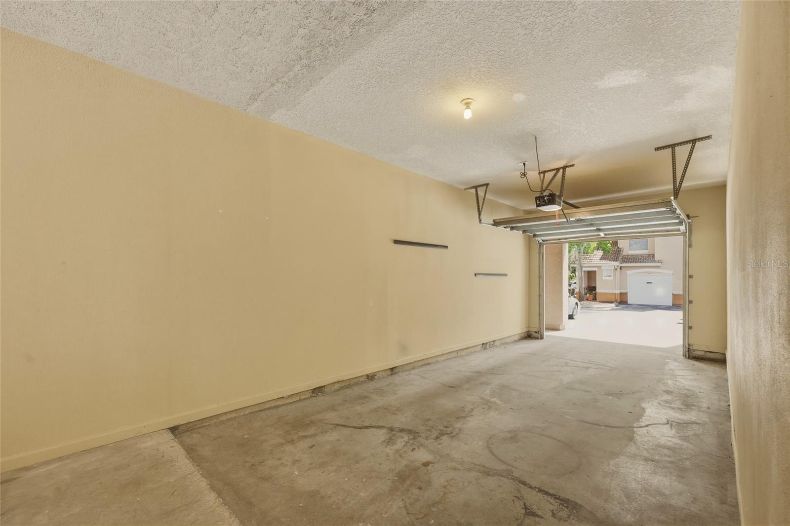 Oversized one car garage with additional storage space at rear and a designated storage area as well.